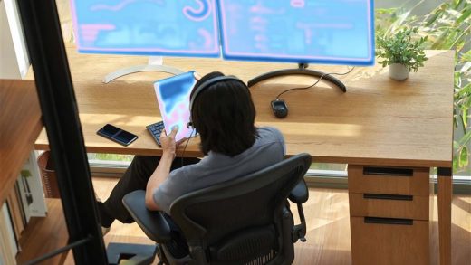 A person sitting at a desk with a computer and tablet