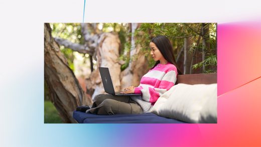 A woman sitting on a bench with a laptop