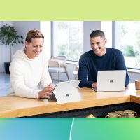 A couple of men looking at laptops