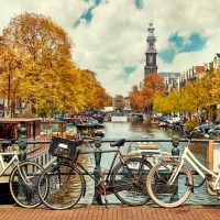 Bike over canal Amsterdam city. Picturesque town landscape in Netherlands with view on river Amstel.