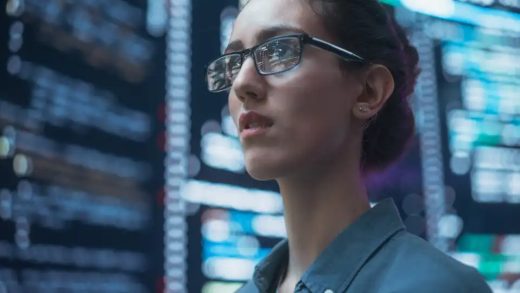 Close Up Portrait of Woman Working on Computer, Lines of Code Language Reflecting on her Glasses from Big Display Screens. Female Programmer Developing New Software, Coding, Managing Cybersecurity
