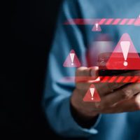 System warning caution sign on smartphone, scam virus attack on firewall for notification error and maintenance. Network security vulnerability, data breach, illegal connection and information danger.