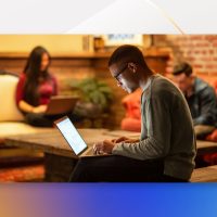 Male developer working remotely from a cafe.