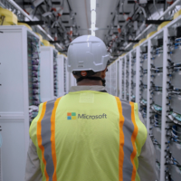 An employee standing between server racks at a Microsoft AI datacenter.