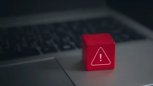 Red-warning-cube-on-a-laptop-keyboard Sicherheitslücke Alarm