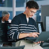 Man, programmer and office with laptop for coding, software development or app design. Male person, coder or developer with computer or technology for cybersecurity, web or IT services at workplace