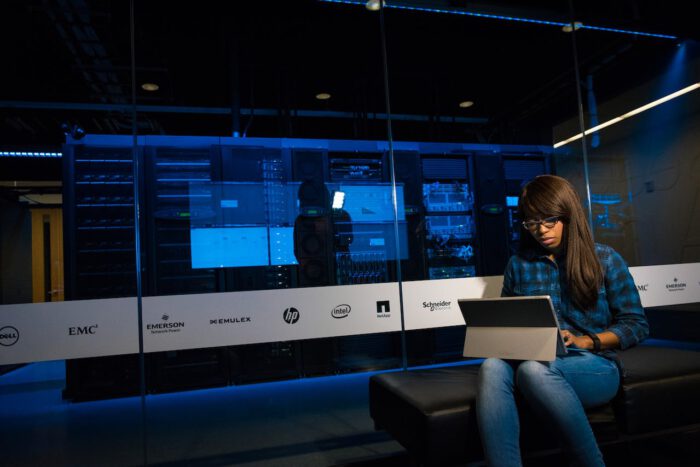 Black woman using computer in server room