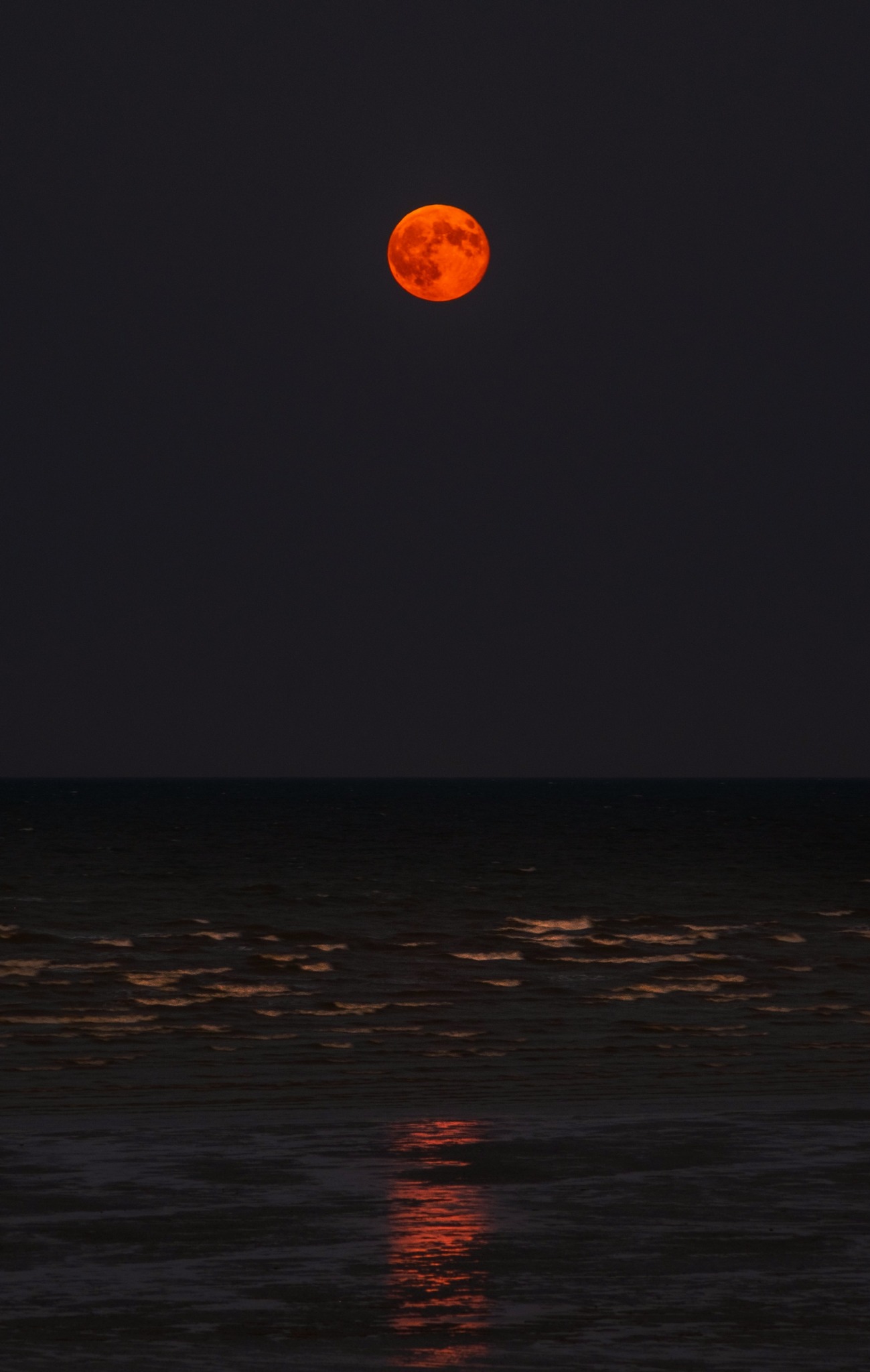 Harvest moon over calm sea