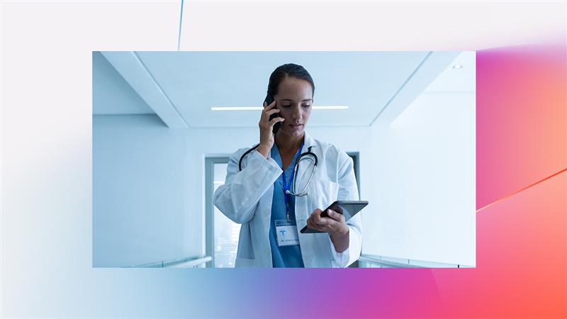 A woman in a white coat holding a tablet and talking on the phone