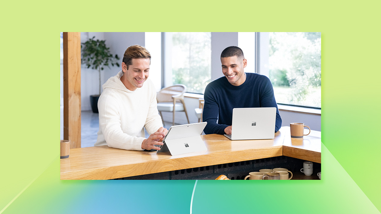 A couple of men looking at laptops