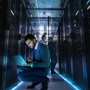 4180943 0 11913500 1780913046 it technician works on laptop in data center full of servers with mult.webp