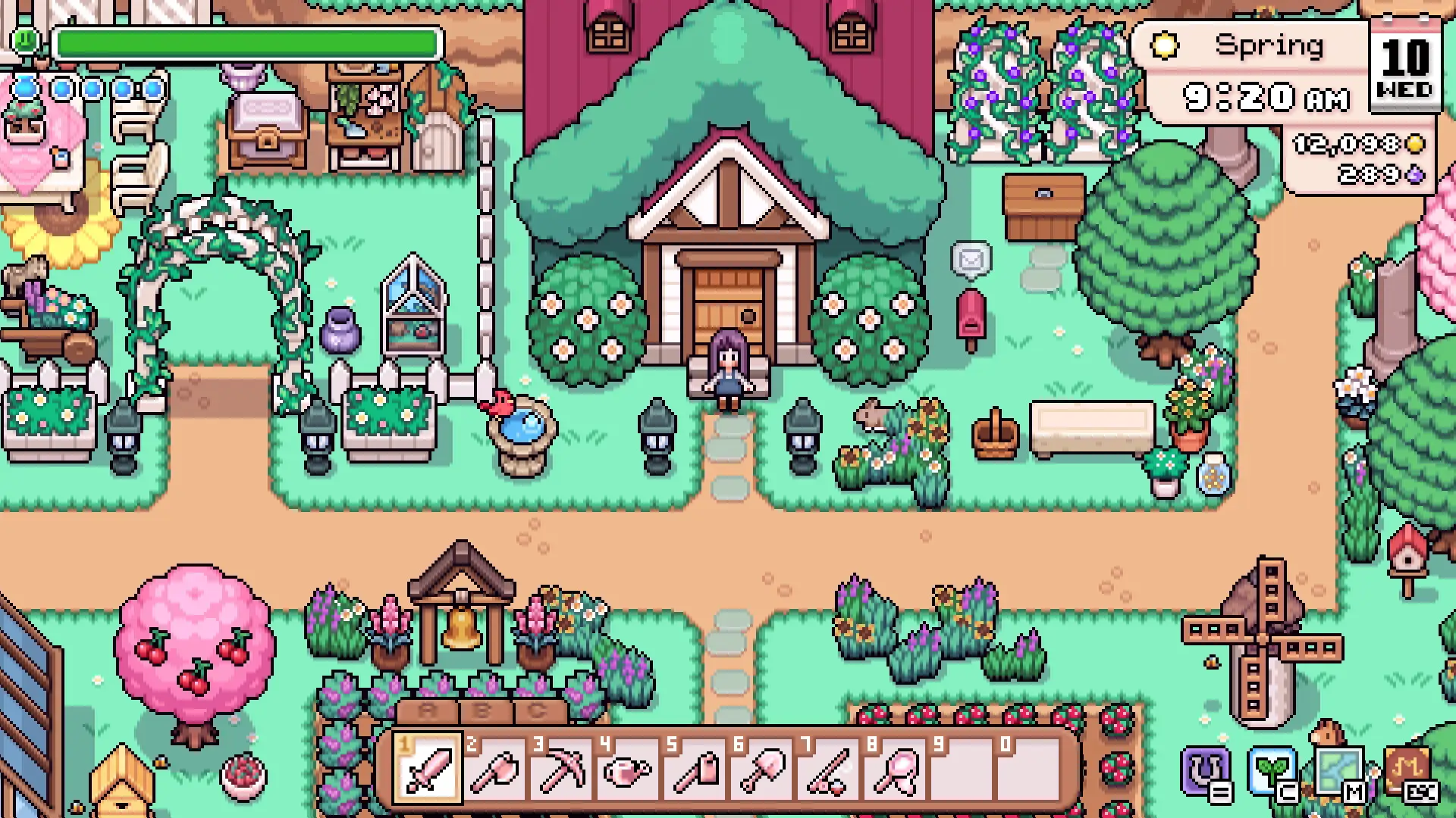 A spring corner of Mistria with flower arches over the path, planted garden beds, a blossom tree and a small shrine beside the water