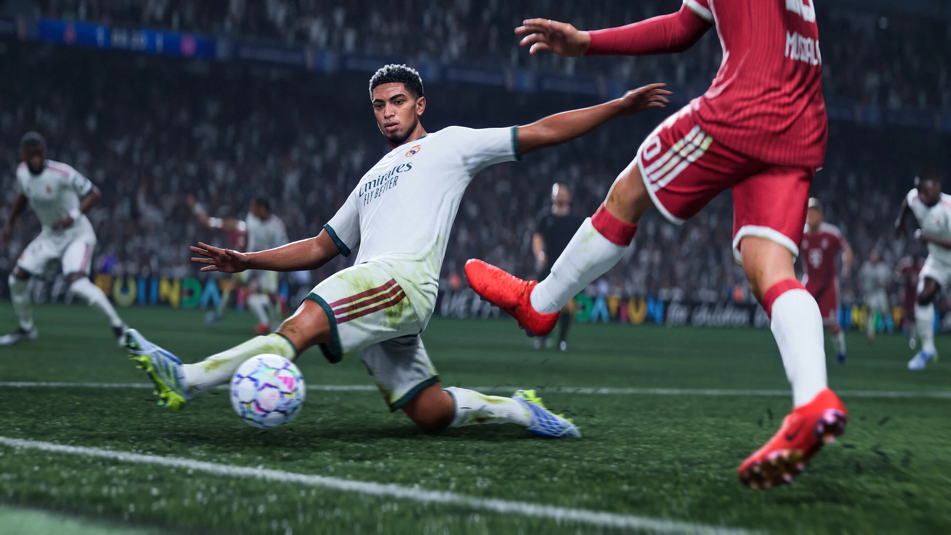 A player in a white kit slides in to win the ball from an opponent in red