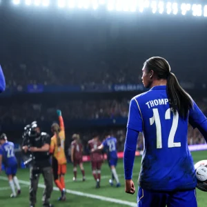 A player in a blue kit wearing number 12 walks to take a throw in while a teammate claps from the touchline