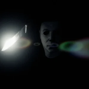 Michael Myers barely visible in near total darkness with a knife blade catching a point of light