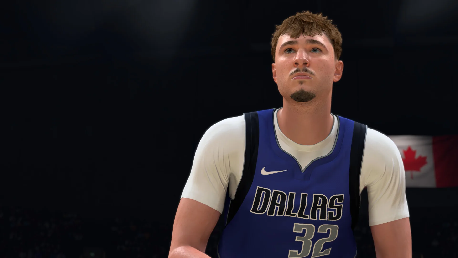Close up of a Dallas Mavericks player in a blue number 32 jersey on a darkened court in NBA 2K27