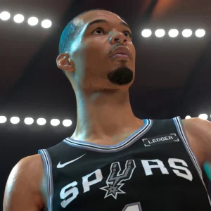 Victor Wembanyama in a black San Antonio Spurs jersey looking up under arena lights in NBA 2K27