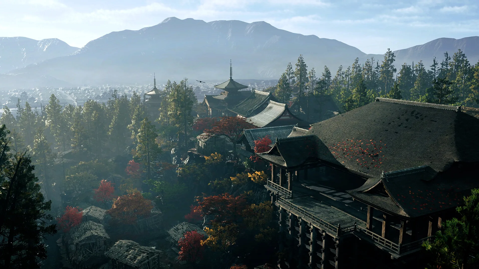 Wide view over Kyoto temple rooftops with autumn trees and misty mountains in the distance