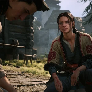 Coen and a woman sitting together outside a cottage in The Blood of Dawnwalker