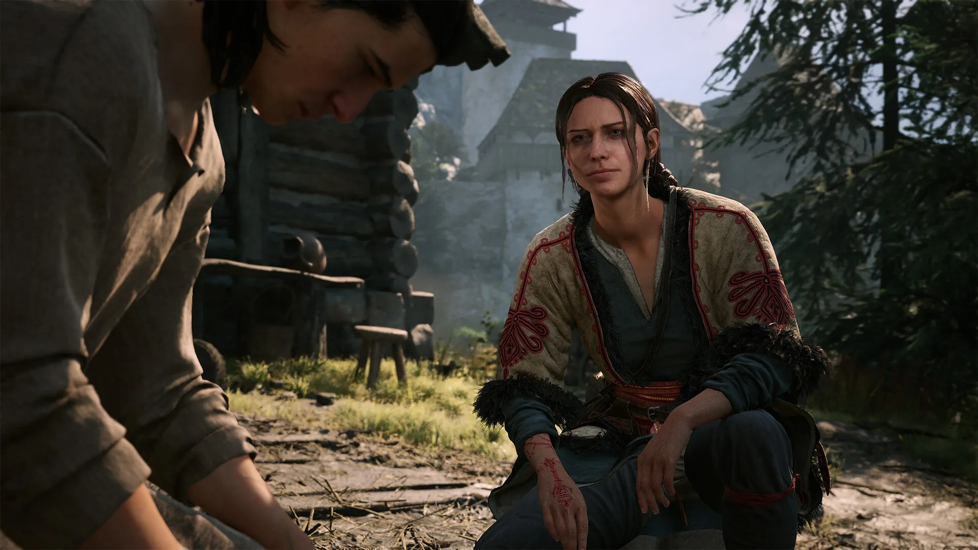 Coen and a woman sitting together outside a cottage in The Blood of Dawnwalker