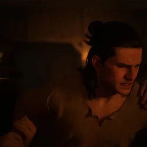 Coen comforting a wounded man in a dim interior in The Blood of Dawnwalker