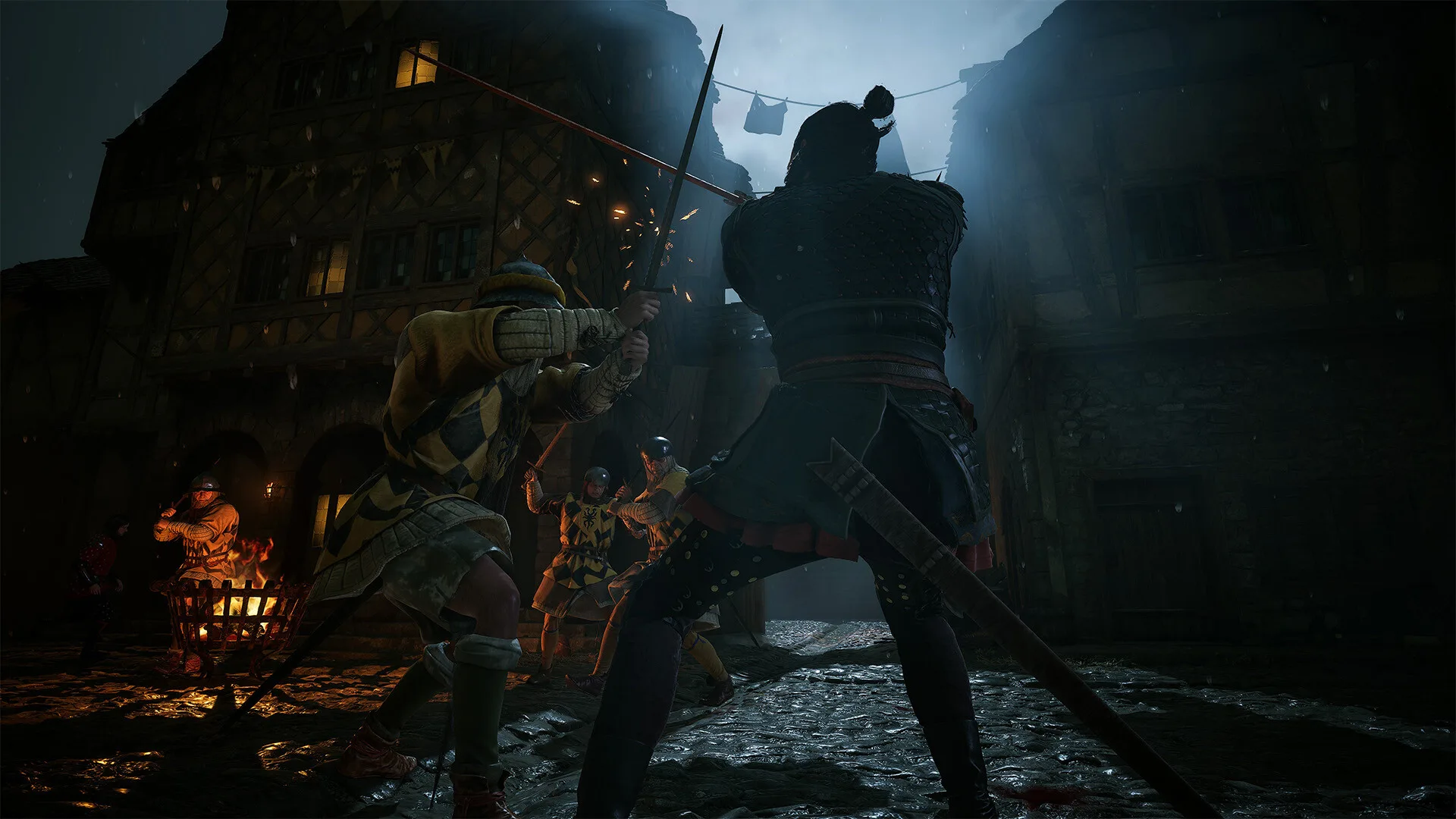 Coen in a sword fight on a torchlit village street at night in The Blood of Dawnwalker