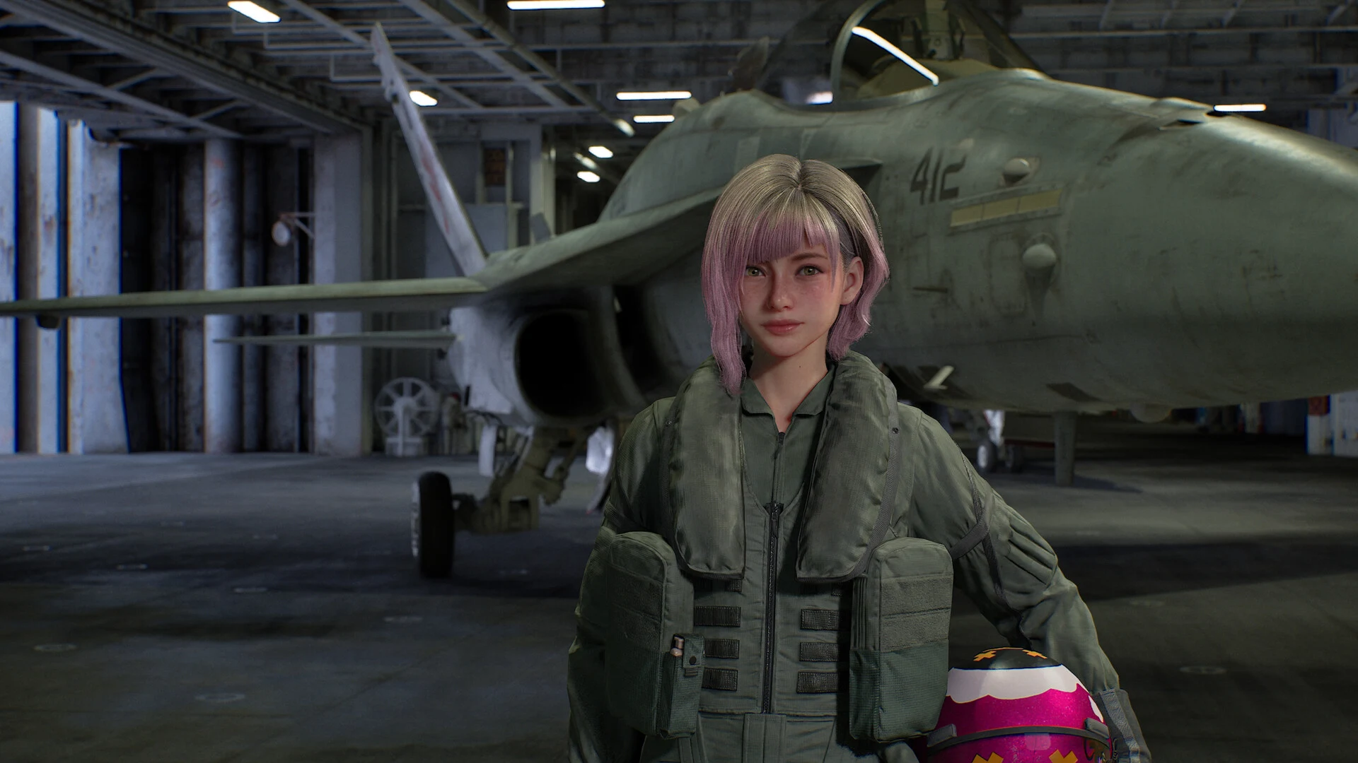 A pilot with pink hair in a green flight suit holds her helmet in a carrier hangar, standing in front of a parked fighter jet