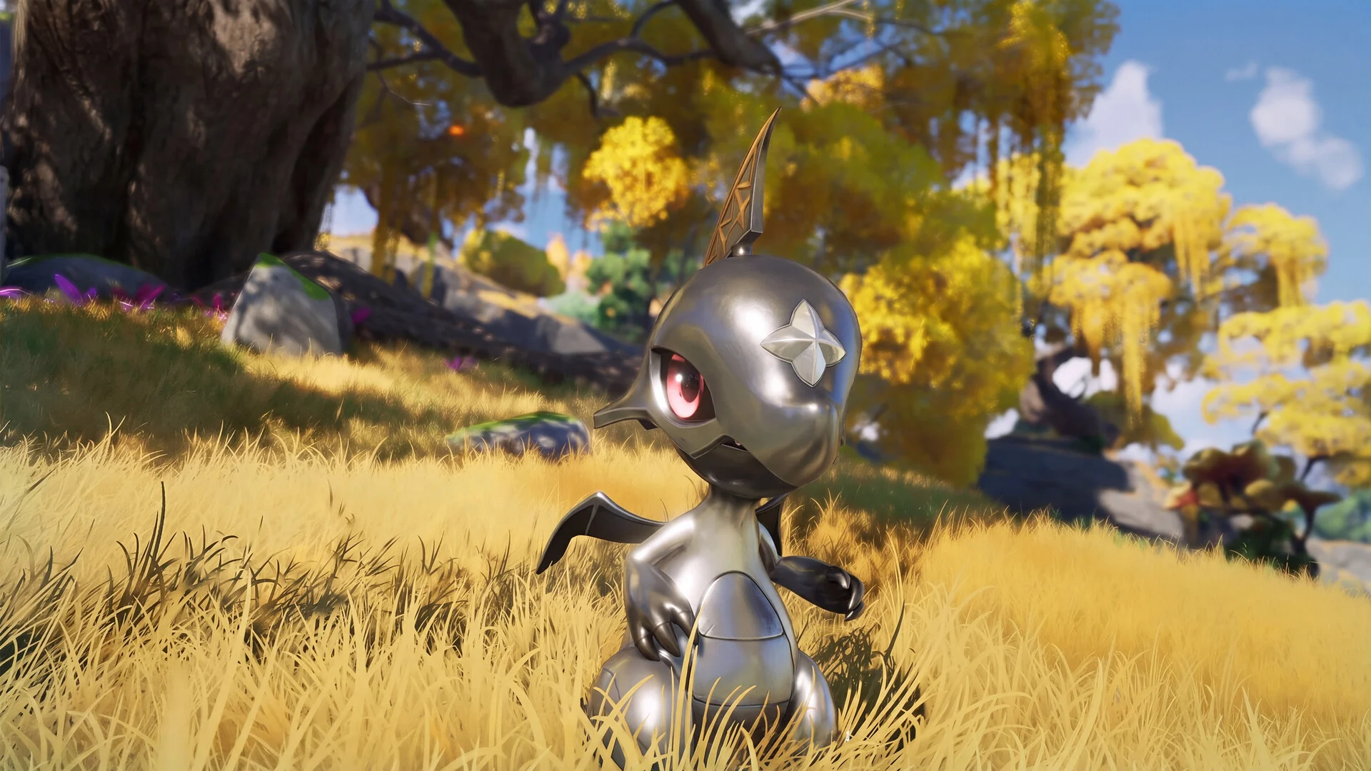 A small silver Aniimo with red eyes standing in tall golden grass under autumn trees