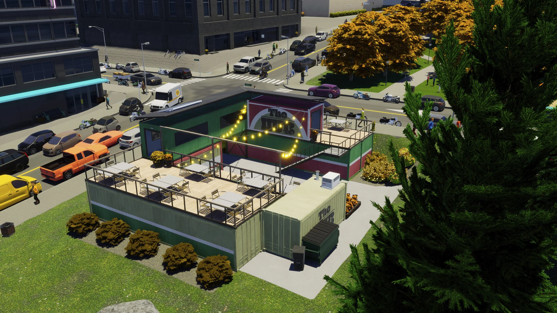 A market hub built from stacked shipping containers, with outdoor seating, string lights and parked cars around it