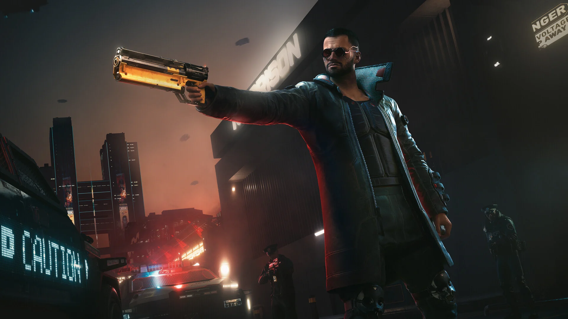 A man in sunglasses and a long black coat aims a gold revolver on a rooftop at night, with police lights below