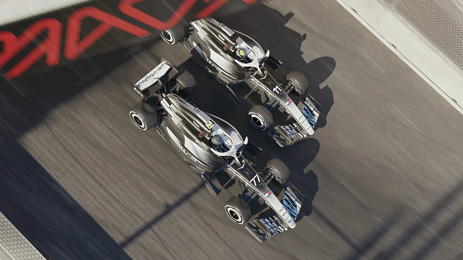 Top-down view of two silver 2026 cars racing side by side past the Madring logo painted on the track in F1 25