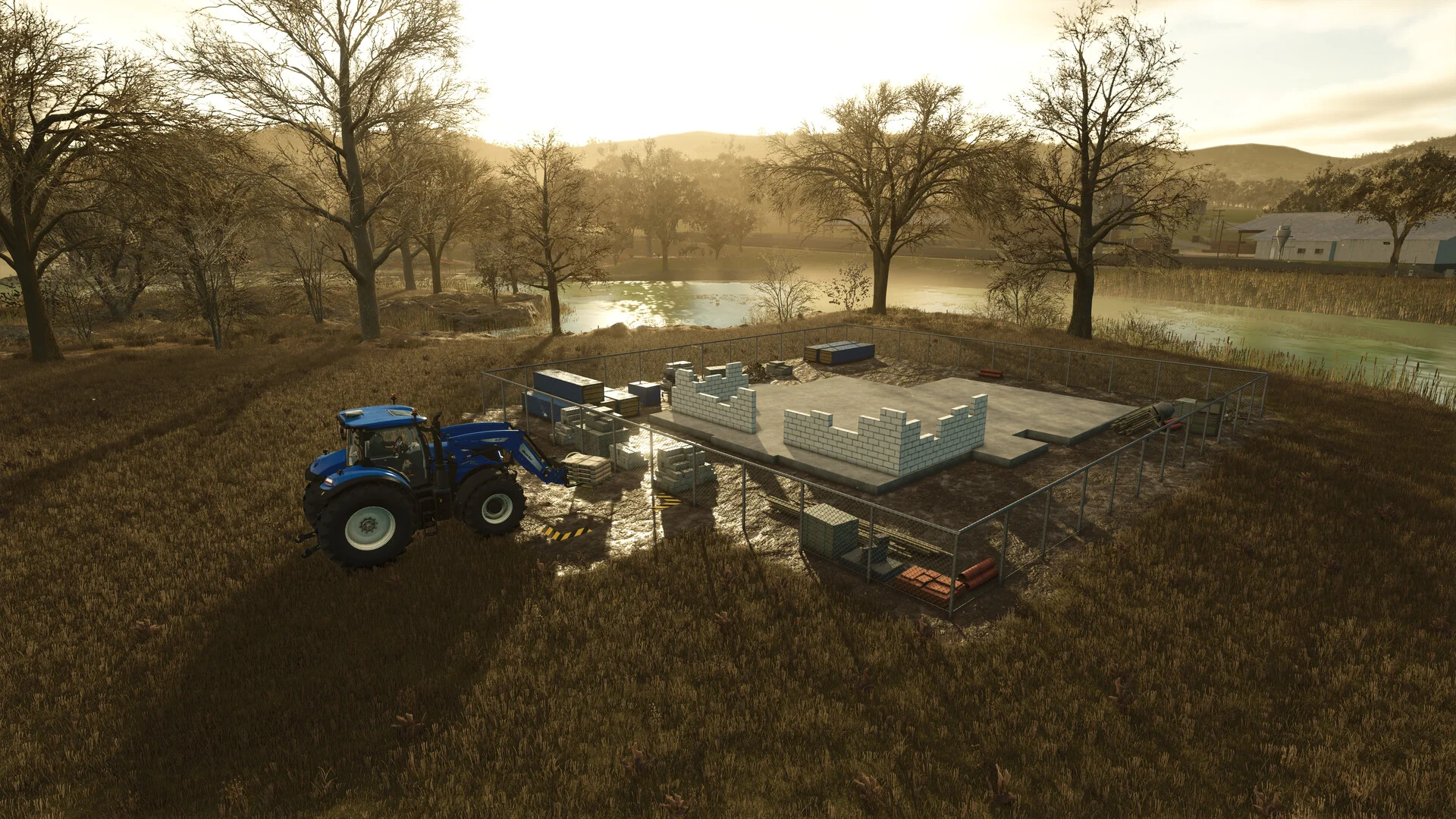 A tractor delivers pallets of building materials to a construction site beside a lake in Farming Simulator 25