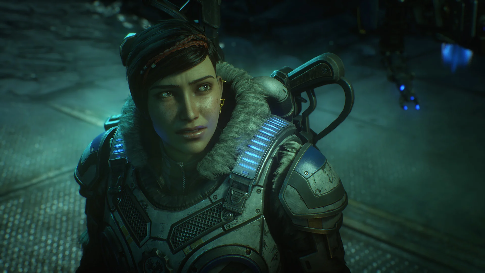 Kait Diaz, the lead character of Gears 5, looks over her shoulder in a dim green-lit room