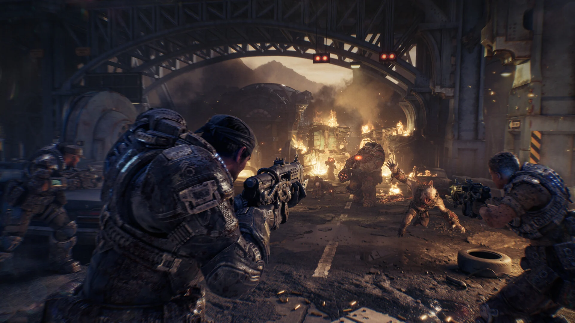 COG soldiers crouch behind cover and fire at Locust attackers charging through a burning street under a steel bridge
