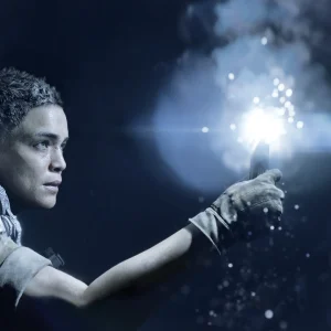 A young soldier holds a bright flare out into a dark underground space