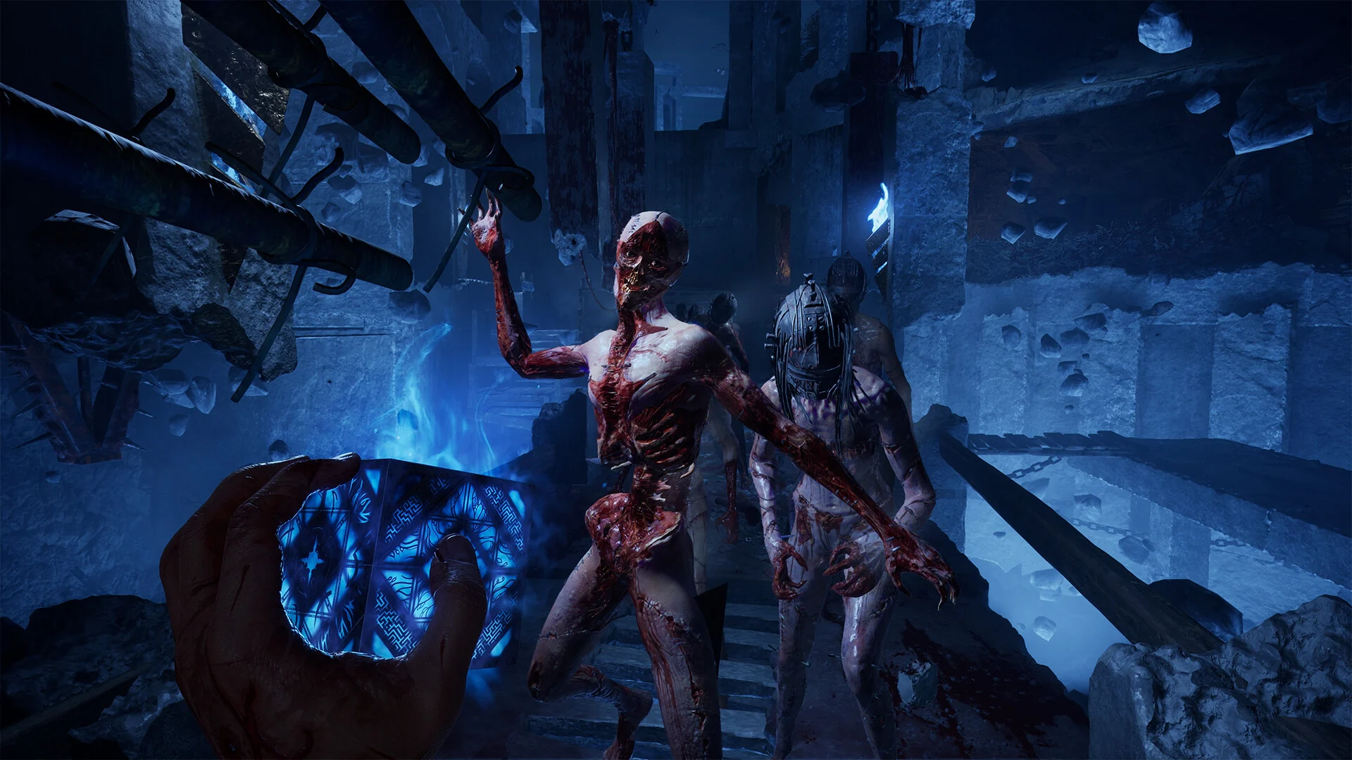 Two skinless, bloody creatures lunge at the player in collapsed ruins while the puzzle box glows blue in the player's hand