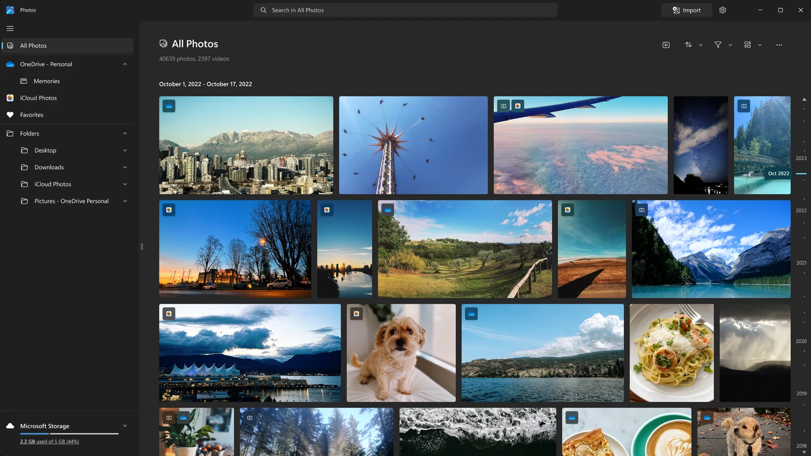 Microsoft Photos All Photos gallery in dark mode with OneDrive, iCloud Photos and local folders listed in the left menu
