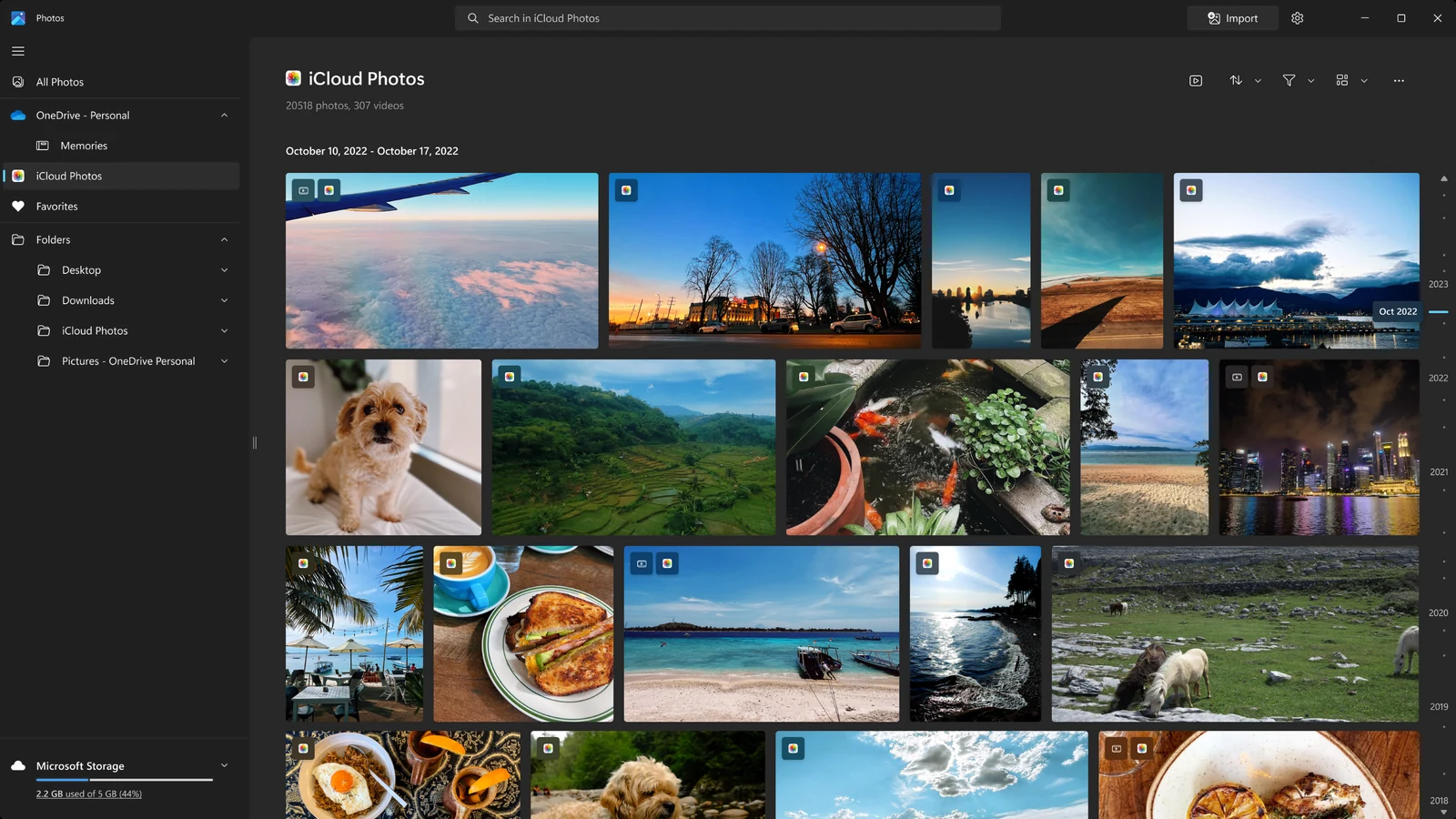 Microsoft Photos showing an iCloud Photos gallery of travel, food and dog pictures inside the Windows app