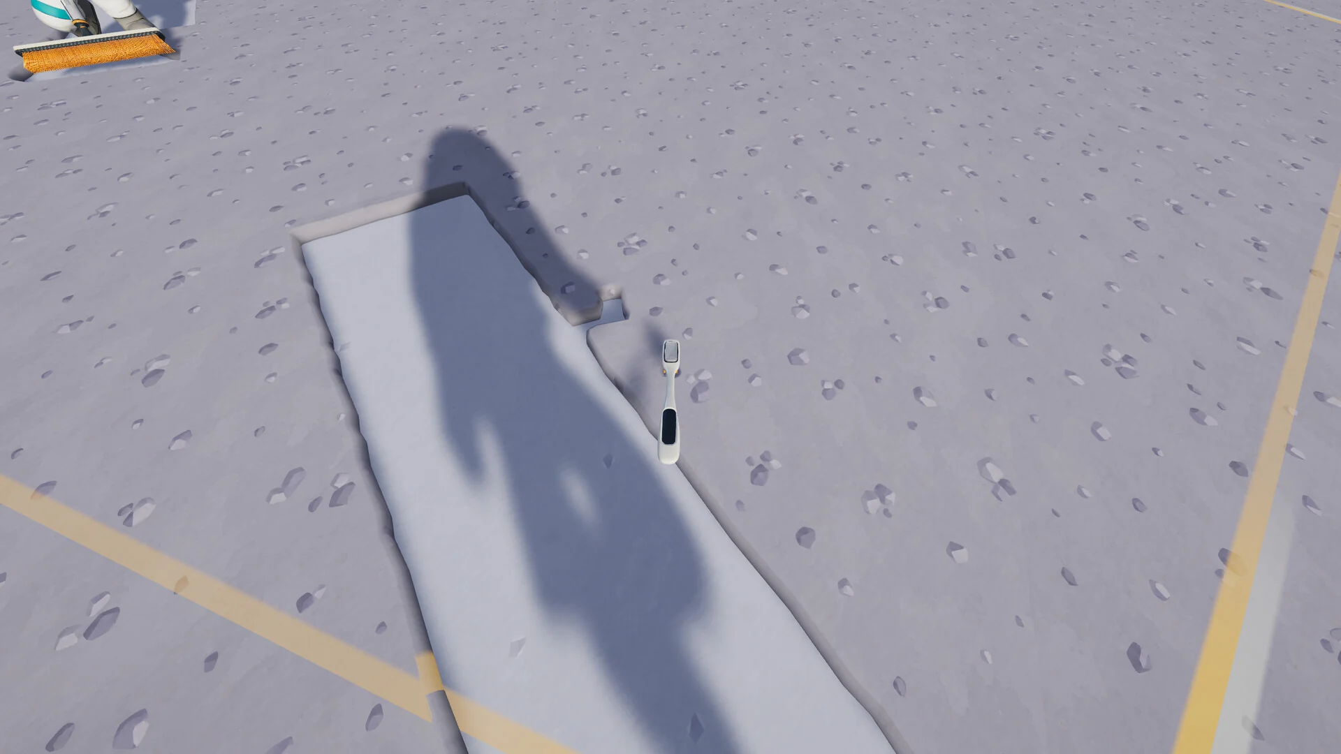 The astronaut's shadow falls across a clean path brushed through the cratered lunar dust