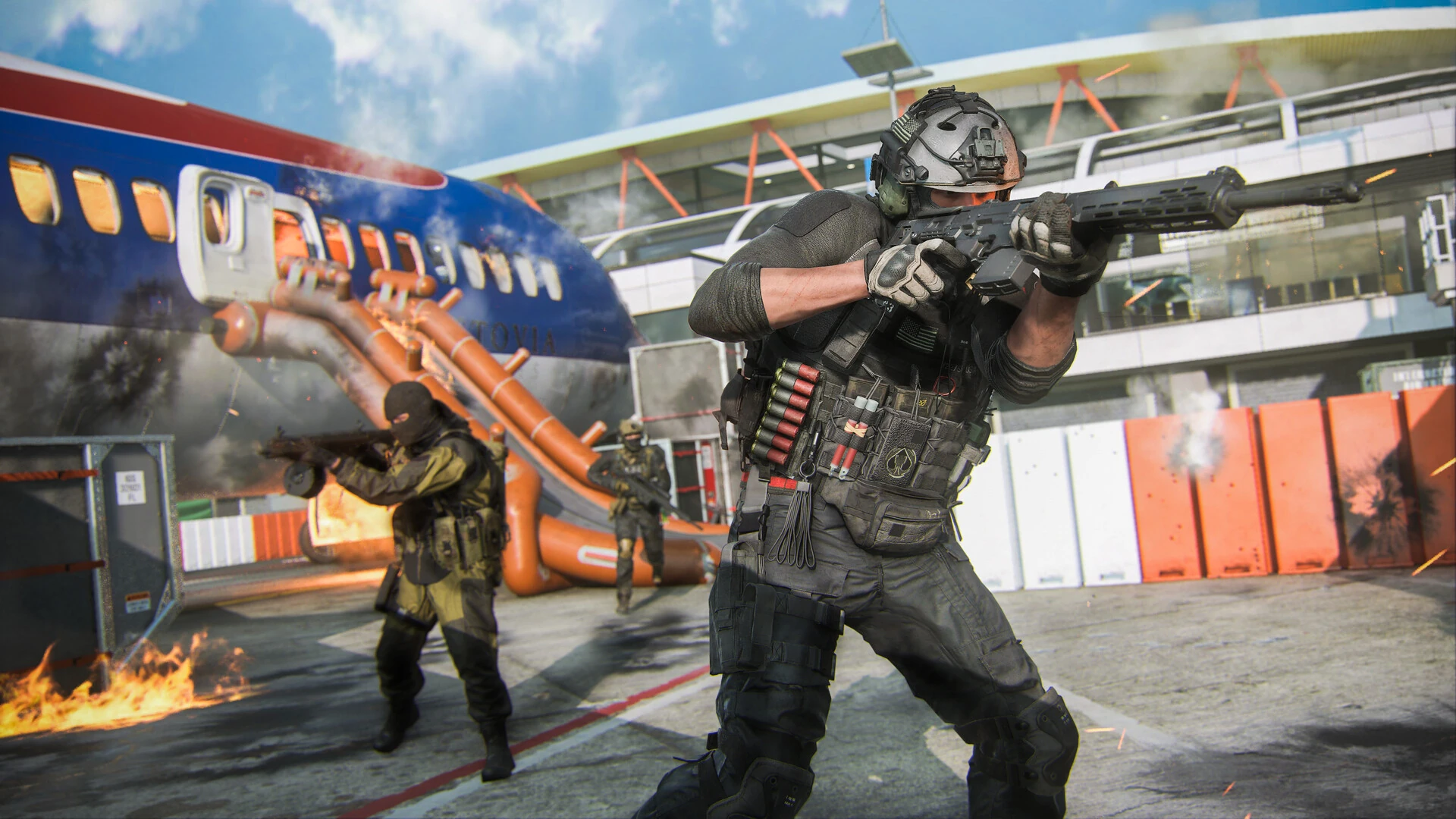 An operator aims a rifle beside a parked passenger jet with its emergency slide deployed at an airport terminal