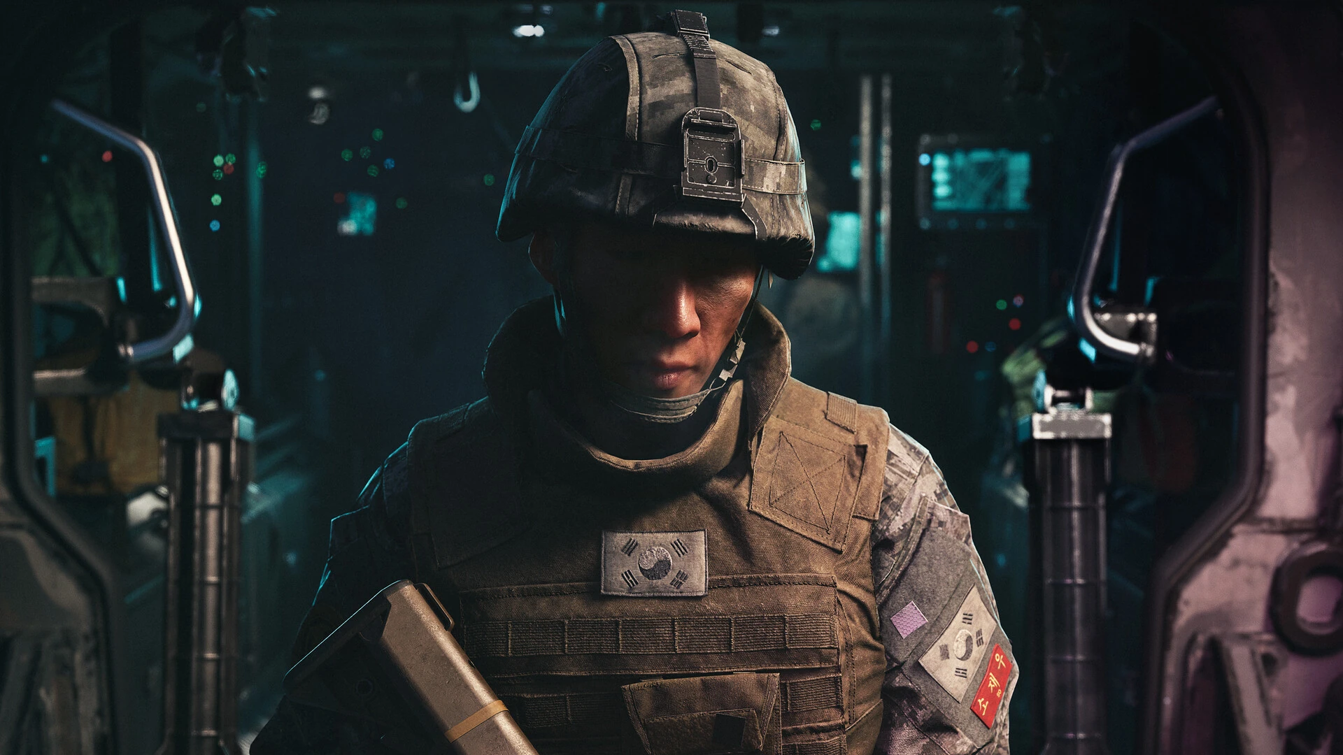 A young South Korean soldier in a helmet and armor vest sits inside a dark military vehicle