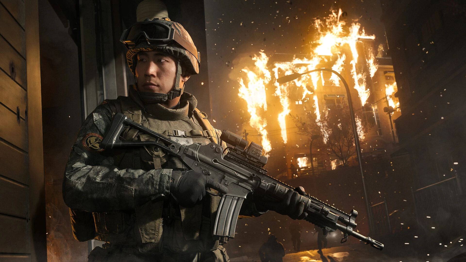 A South Korean soldier in a helmet and combat gear holds a rifle at night as a building burns behind him in Call of Duty: Modern Warfare 4