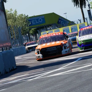 Two Craftsman Truck Series pickups battle side by side through a corner of the St. Petersburg street circuit lined with palm trees