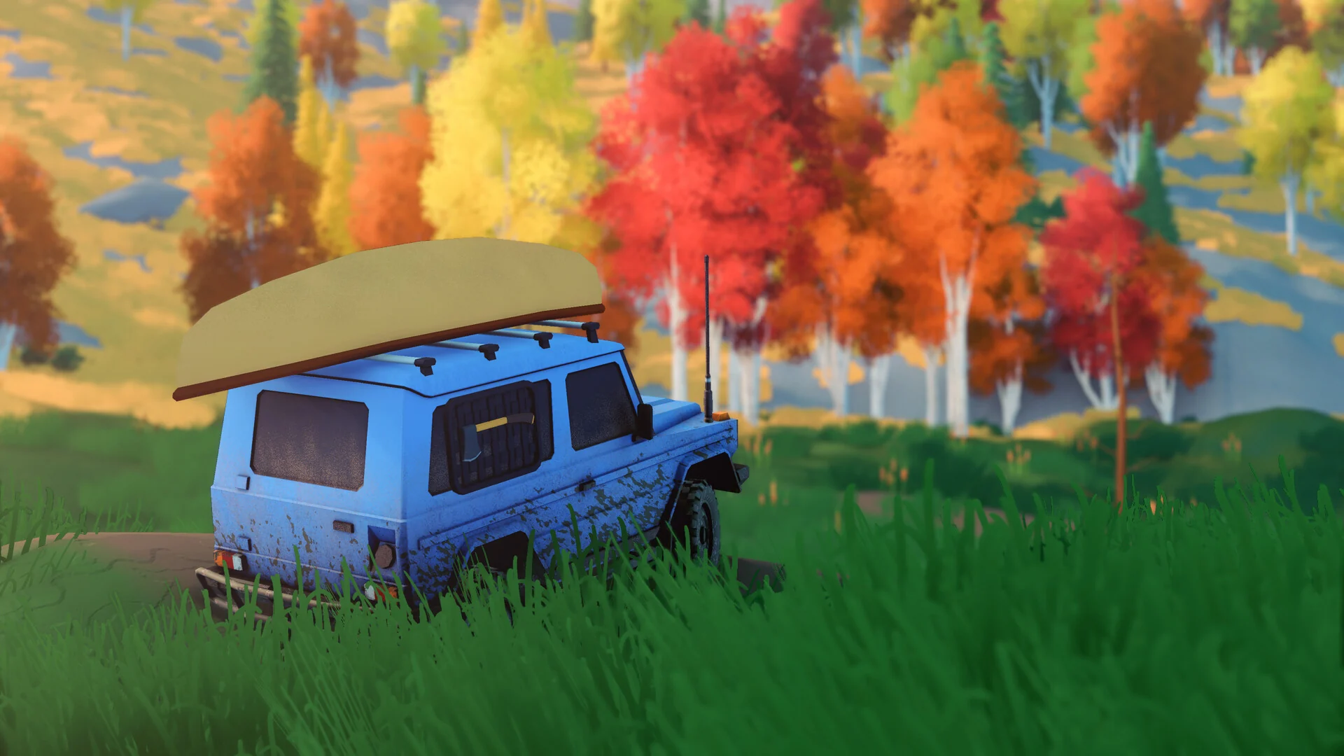 A blue 4x4 with a canoe strapped to the roof parks in tall grass among red, orange and yellow autumn trees