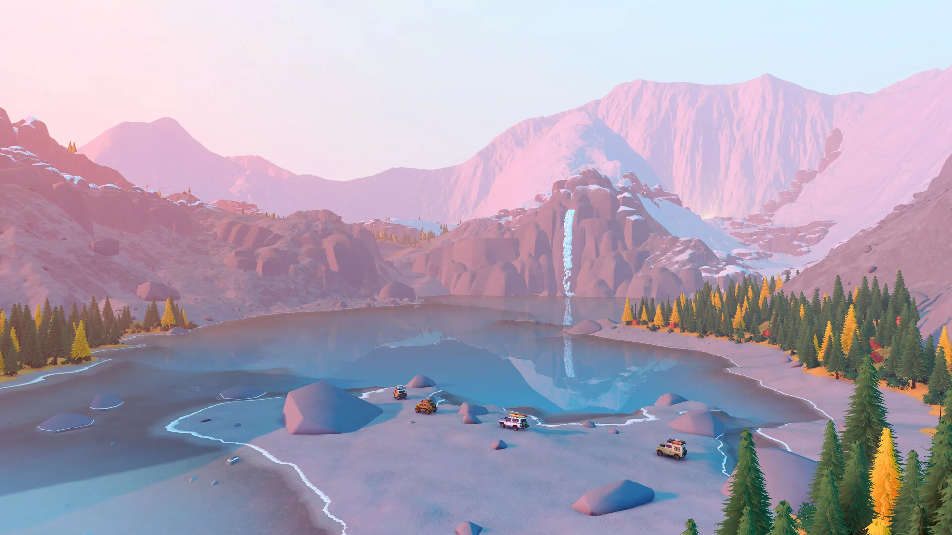 A convoy of tiny 4x4s drives along the shore of a still mountain lake below a waterfall and pink peaks