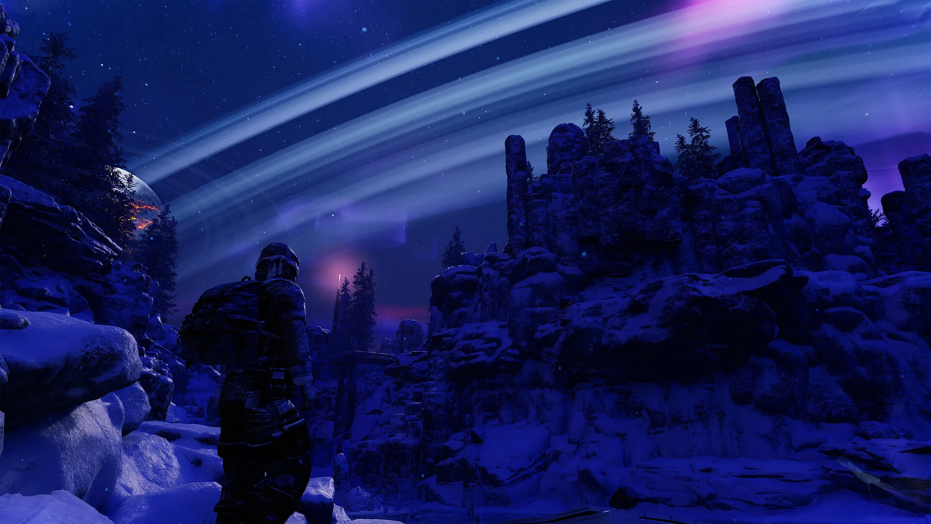 A survivor stands on snowy rocks at night looking at bright rings of moon debris arcing across the sky