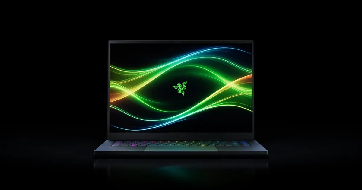 A black Razer Blade 16 laptop on a dark background with a green and blue wave wallpaper on screen