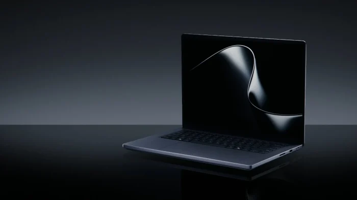 Surface Laptop Ultra open on a dark reflective surface with a black ribbon wallpaper on the screen