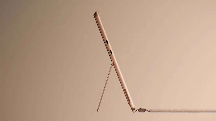 Side view of a Surface Pro in Dune standing on its kickstand with the keyboard attached at a low angle
